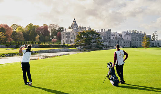 Golf player and his caddy playing golf on the Golf Course at Adare Manor