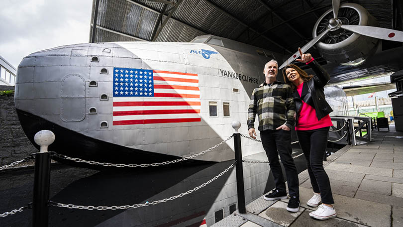 Couple standing in front of a replica flying boat at Foynes Flying Boat Museum