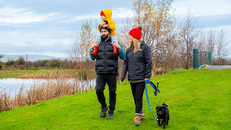 Family with young kids and black dog walking at the Killeedy Eco Park in Co. Limerick