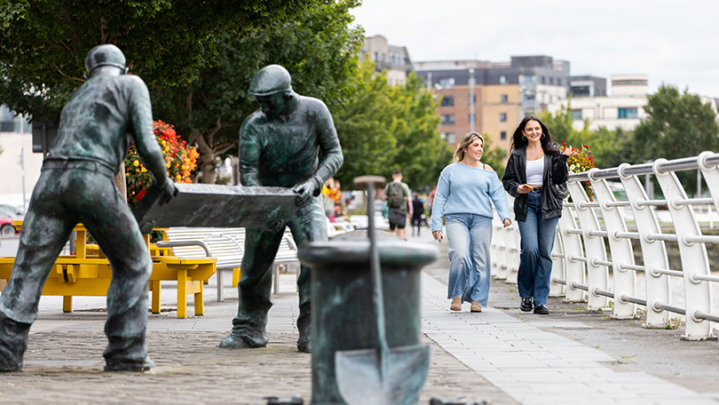 Two young women walking along the boardwalk on the Three Bridges Walk in Limerick