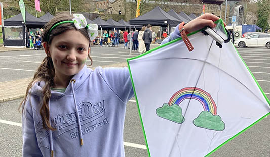 Girl holding St. Patrick's Day themed kite