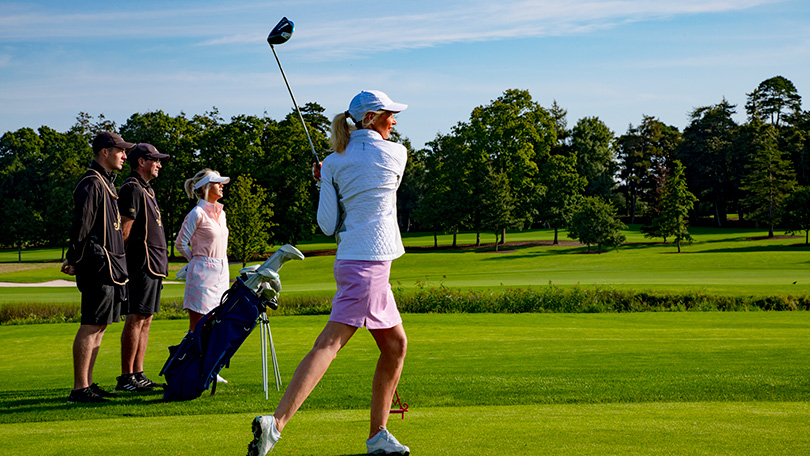 Women in white top and pink shorts playing golf at Adare Manor