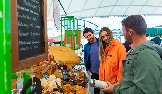 Three people browsing at a stall in Limerick Milk Market