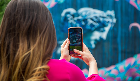 Woman taking a photo of Street Art in Limerick City