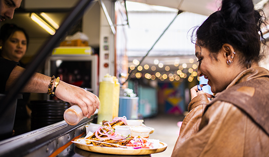 Woman being served a pizza from a street food truck at the Wickham Way in Limerick City