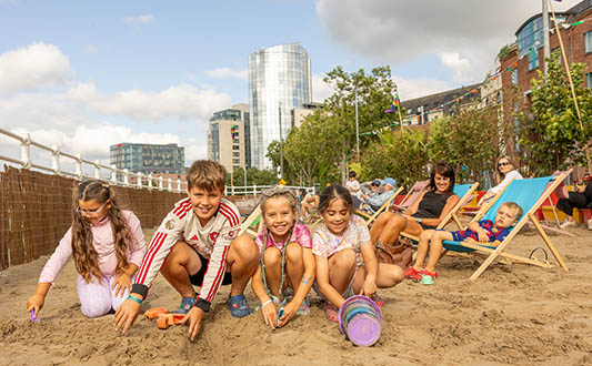 Group of kids playing in the sand at the urban beach in Limerick as part of Summer in the City. Photo: Kieran Ryan Benson