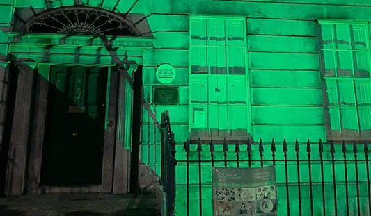 The front of the People's Museum of Limerick lit up with green lighting